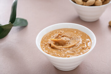 Bowl with tasty peanut butter on table