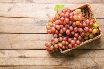 Sweet ripe grapes in box on wooden background