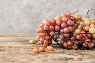 Bowl with sweet ripe grapes on wooden table