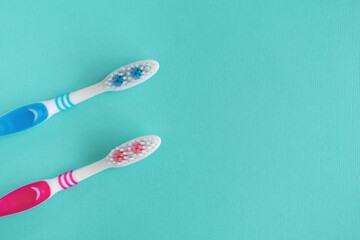 Two toothbrushes on a blue background. Copy space