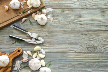 Garlic press with cloves on table