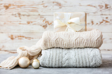 Fototapeta na wymiar Stylish Christmas clothes with gift on table