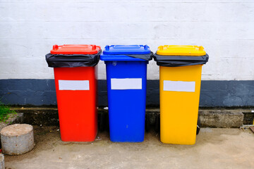 Waste management trash separated by color: red for hazardous waste, blue for general waste and yellow for recyclable waste.