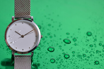 Women's watch on a green table. 