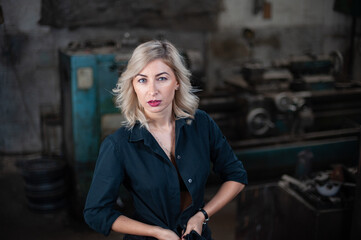 Portrait of a beautiful young blonde woman with blue eyes with old machinery 