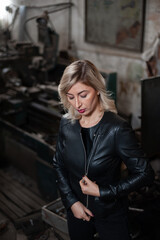 Portrait of a beautiful young blonde woman with blue eyes with old machinery 