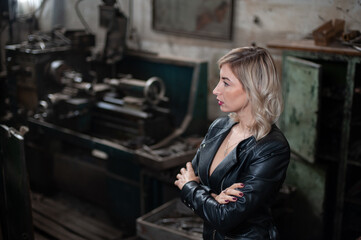Portrait of a beautiful young blonde woman with blue eyes with old machinery 