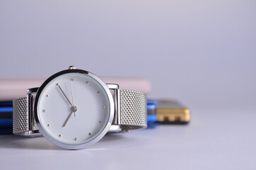 Women's watch, phone, flash drive and notepad on the table.