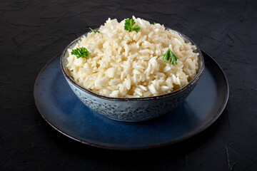 Cooked rice with fresh parsley leaves, in a bowl