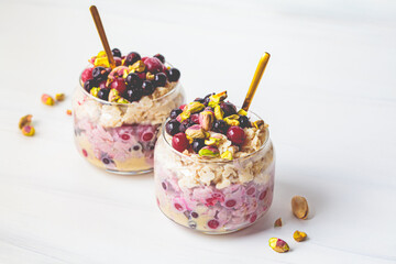 Overnight oats with berries and nuts in a jar on a white background, copy space. Healthy breakfast...