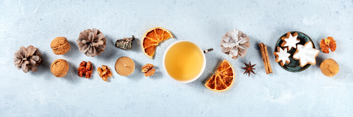 Flat lay Christmas panorama. Tea, cookies, spices, dried fruit, cozy handmade layout for a sustainable winter holidays banner. Shot from above