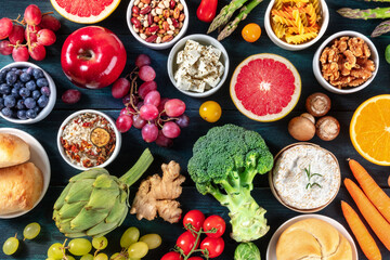 Vegetarian food variety. Fruit and vegetables, cheese, legumes, nuts, mushrooms, shor from the top on a dark background