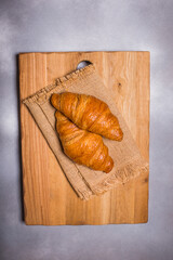 French croissant. Freshly baked croissants with jam on wooden background. Tasty croissants with copy space