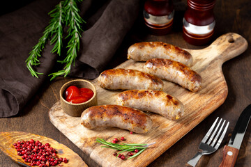 Fried sausages. Grilled sausages with spices on a wooden serving Board. Delicious meat sausages