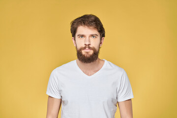 Fototapeta na wymiar Bearded man on emotions white t-shirt fun lifestyle yellow background