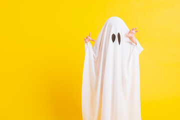 Funny Halloween Kid Concept, Closeup a little cute child with white dressed costume halloween ghost...