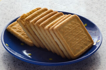 Delicious biscuits on a blue saucer and marble top.