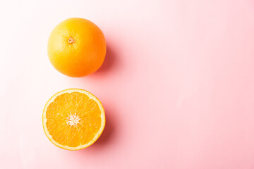 Top view of Fresh half orange fruit slice and full orange in the studio shot isolated on pink background, Healthy food concept