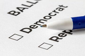 Checklist concept. Closeup of ballot paper with words Democrat and Republican with checkboxes and pen on it.