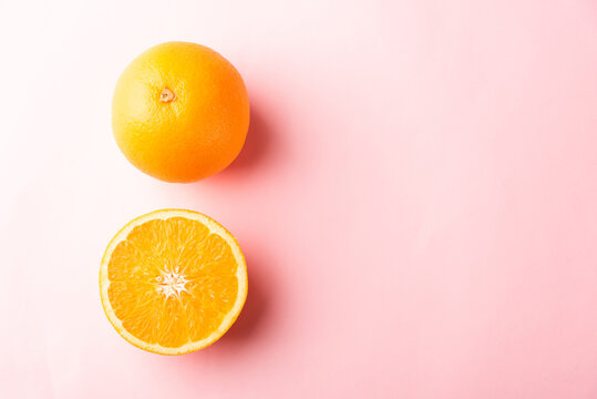 Top View Of Fresh Half Orange Fruit Slice And Full Orange In The Studio Shot Isolated On Pink Background, Healthy Food Concept