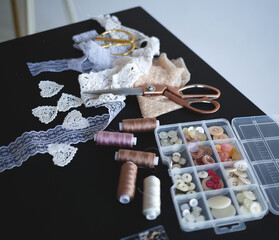 a stack of fabrics and sewing accessories on a tailor's table