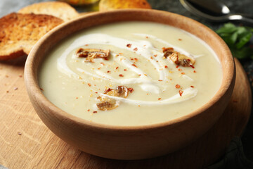 Wooden bowl with tasty mushroom soup, close up