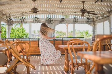 girl dancing in cafe on the beach. young slim beautiful woman on sunset beach, playful, dancing, running, bohemian outfit, indie style, summer vacation, sunny, having fun, positive mood, romantic