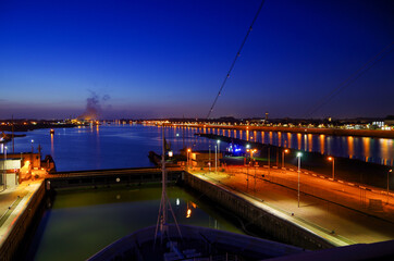Large modern cruiseship or cruise ship liner passes or transits Ijmuiden locks during twilight...