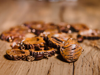 Close up of  brown peach seed imitation necklace on a striped wooden table top