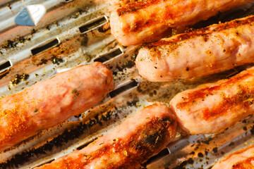 Sausages meat grilling on gas grill