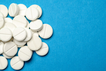 group of white pills or tablets on blue background