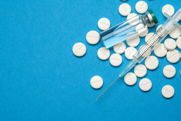 Fototapeta na wymiar Top view of Pills, Syringe And Ampoule With Vaccination On blue background with copy space