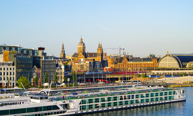 Modern cruiseship or cruise ship liner arrival into port of Amsterdam, Holland with city skyline...