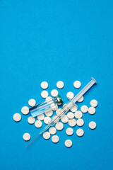 Fototapeta na wymiar Top view of Pills, Syringe And Ampoule With Vaccination On blue background with copy space