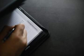 Filling out a form with personal information. Documents in a folder on the table to fill. Handwritten information about the applicant.