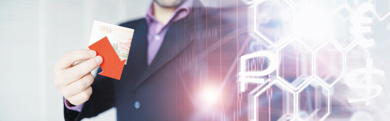 Financial crisis. Concept. Money bills in hand. Arrow symbol of the fall of the national currency. The change in the exchange rate between the Russian ruble and the US dollar.