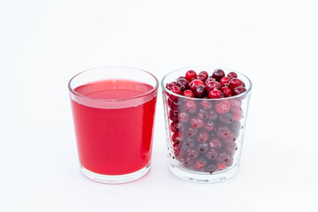 A glass of cranberry juice and a glass with red cranberries on a white background.
