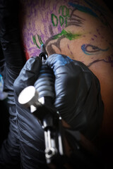 Fototapeta na wymiar Female tattoo artist making tattoo on a men’s arm