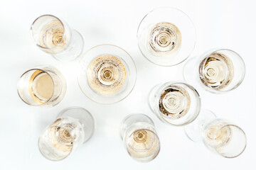 Glasses of champagne and alcohol drinks on white table background