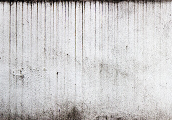 Vertical streaks of dirt on a white textured wall