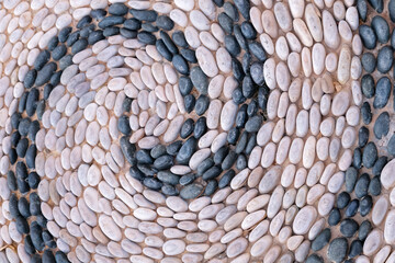 Background image of old cobblestone road backlit with low sunlight. Stone texture close up. Small pebbles on the road.