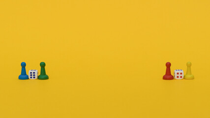 Two dice and multi-colored playing chips: red, yellow, blue and green stand on a yellow background on the edges: space for text, banner of Board games for the whole family