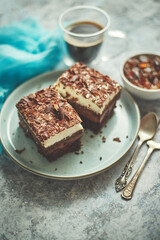 Delicious chocolate cake with layers served on ceramic blue plate. With cup of fresh black coffe
