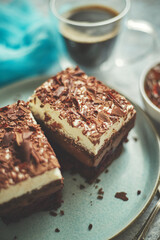 Delicious chocolate cake with layers served on ceramic blue plate. With cup of fresh black coffe