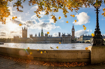Panorama des Westminster Palastes und dem Big Ben Turm in London mit bunten Herbstblättern an den...