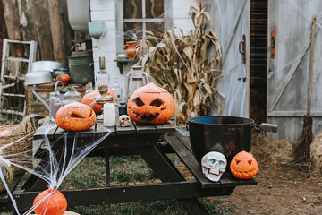 a barn decorated for Halloween with carved pumpkins and cobwebs