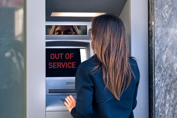 Lady can't withdraw cash money from credit card at bank machine. ATM is out of service, broken bank machine