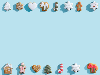 Blue Christmas advertising background. Cookie pattern frame. New Year party ornament. Homemade gingerbread biscuit diverse collection festive composition isolated on light copy space.