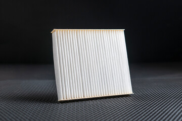 a new square white car air filter for cabin flat lay on dark background