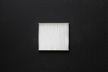 a new square white car air filter for cabin flat lay on dark background
